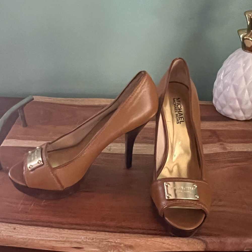 Michael Kors brown leather platform pumps with gold logo name plates.
